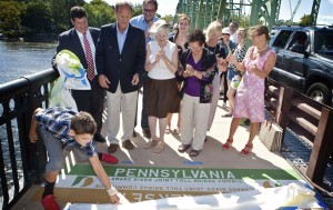Ian Sanders unveils state line to his parents, Ward and Erica Sanders and sister Lilly; DRJTBC Commissioner Yuki Moore Laurenti of New Jersey; DRJTBC Executive Director Joseph Resta; New Hope Mayor Larry Keller; Dee Dee Bowman and Deborah Lang of New Hope Historical Society; Jeff McVey of Lambertville Historical Society; and Tara Shepherd, head of HART Commuter Information Services.