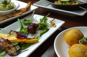(clockwise from lower left) Octopus with mango and aged balsamic, Avocado Yogurt Dip with spiced pita crisps, Fried Cheese "Saganaki," and Goat Cheese and Potato Croquettes with red pepper sauce.
